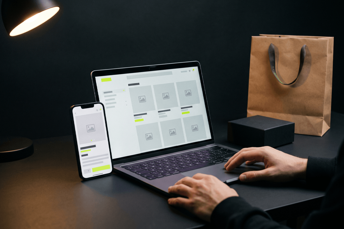 Tienda online en laptop y smartphone con producto y bolsa de compra
